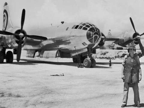 Wearing a helmet and flak jacket and standing in front of The Great Artiste, Tinian 1945