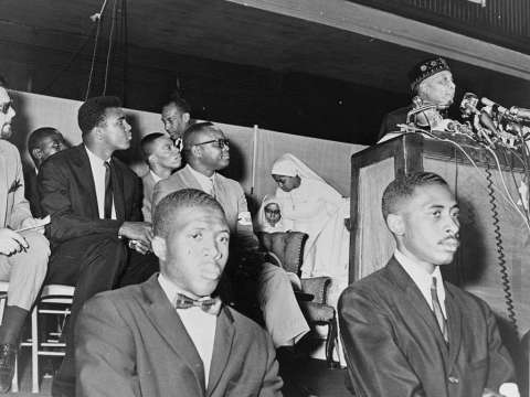  Ali (seen in background) at an address by Elijah Muhammad in 1964