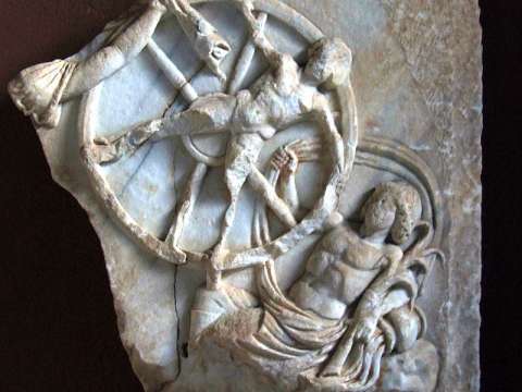Marble relief from the first or second century showing the mythical transgressor Ixion being tortured on a spinning fiery wheel in Tartarus.