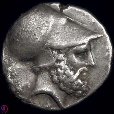 Bearded head with Corinthian helmet, thought to be of Leucippus, sitting dog (Molossian hound?) on the reverse.