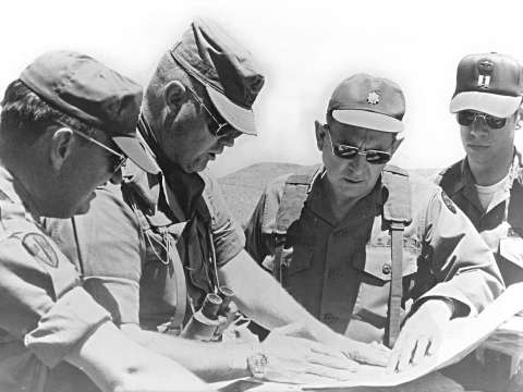 Schwarzkopf, then a colonel, consults with other officers during a training mission in California in 1977.