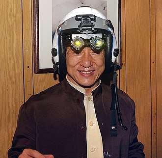 Jackie Chan tries on a fighter pilot's helmet with night vision goggles