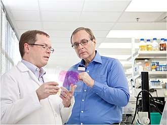Allen (right) studies a brain sample with Allan Jones, CEO of the Allen Institute for Brain Science, in 2011