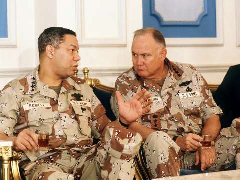Schwarzkopf talks with General Colin Powell, Chairman of the Joint Chiefs of Staff, during a press conference regarding the Gulf War.