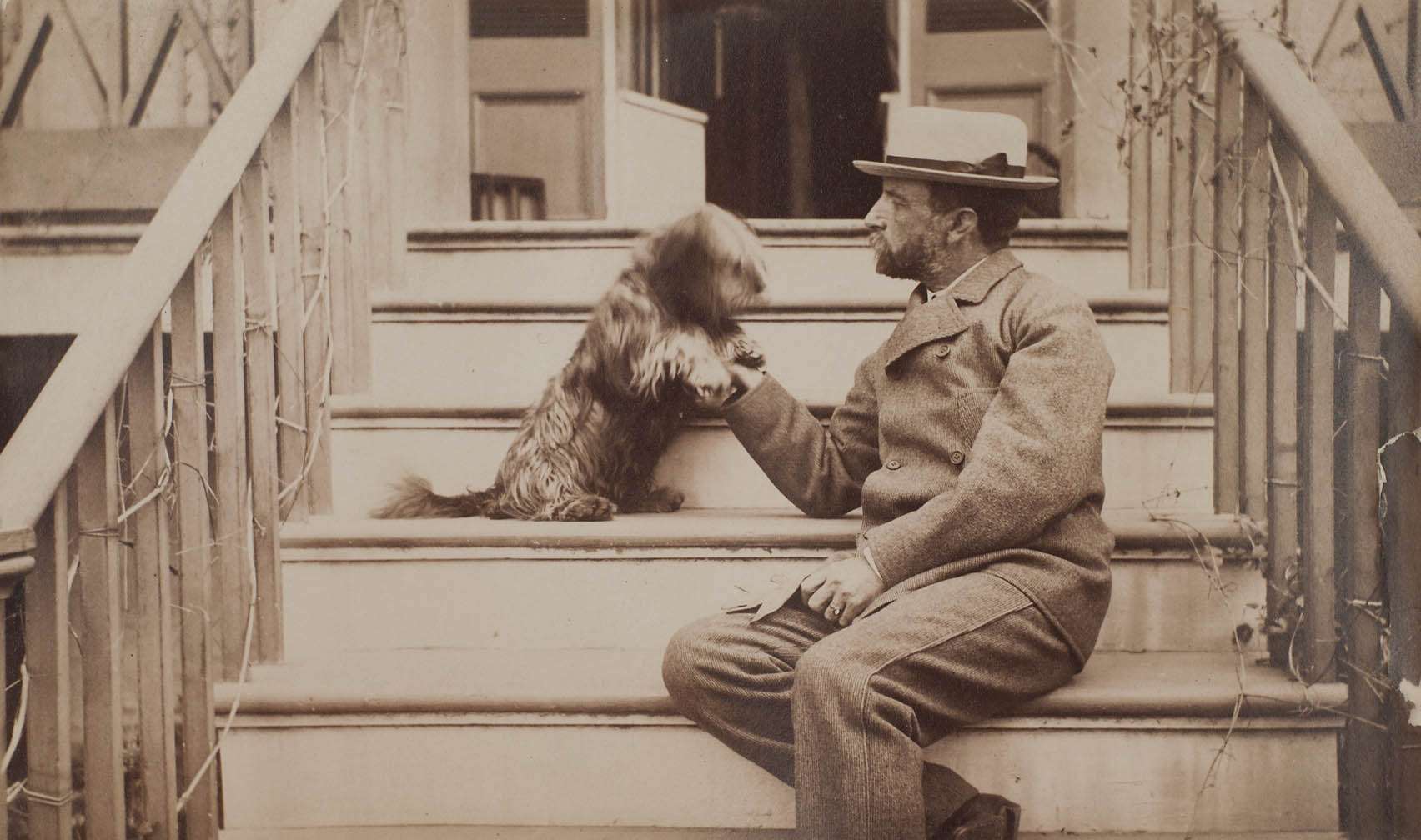 Henry Adams seated with dog on steps of piazza, c. 1883
