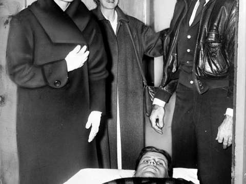 Kennedy lying on a gurney following spinal surgery, accompanied by Jackie, December 1954