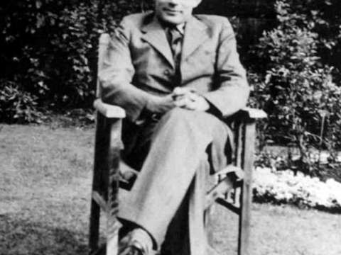 Alan Turing sitting in a chair