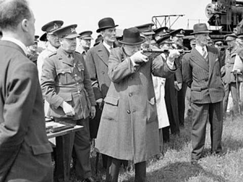 Churchill takes aim with a Sten sub-machine gun in June 1941. The man in the pin-striped suit and fedora to the right is his bodyguard, Walter H. Thompson.