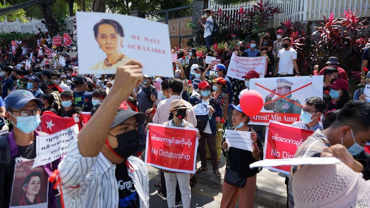 Protesters hold posters with the image of Aung San Suu Kyi during a demonstration against the military coup