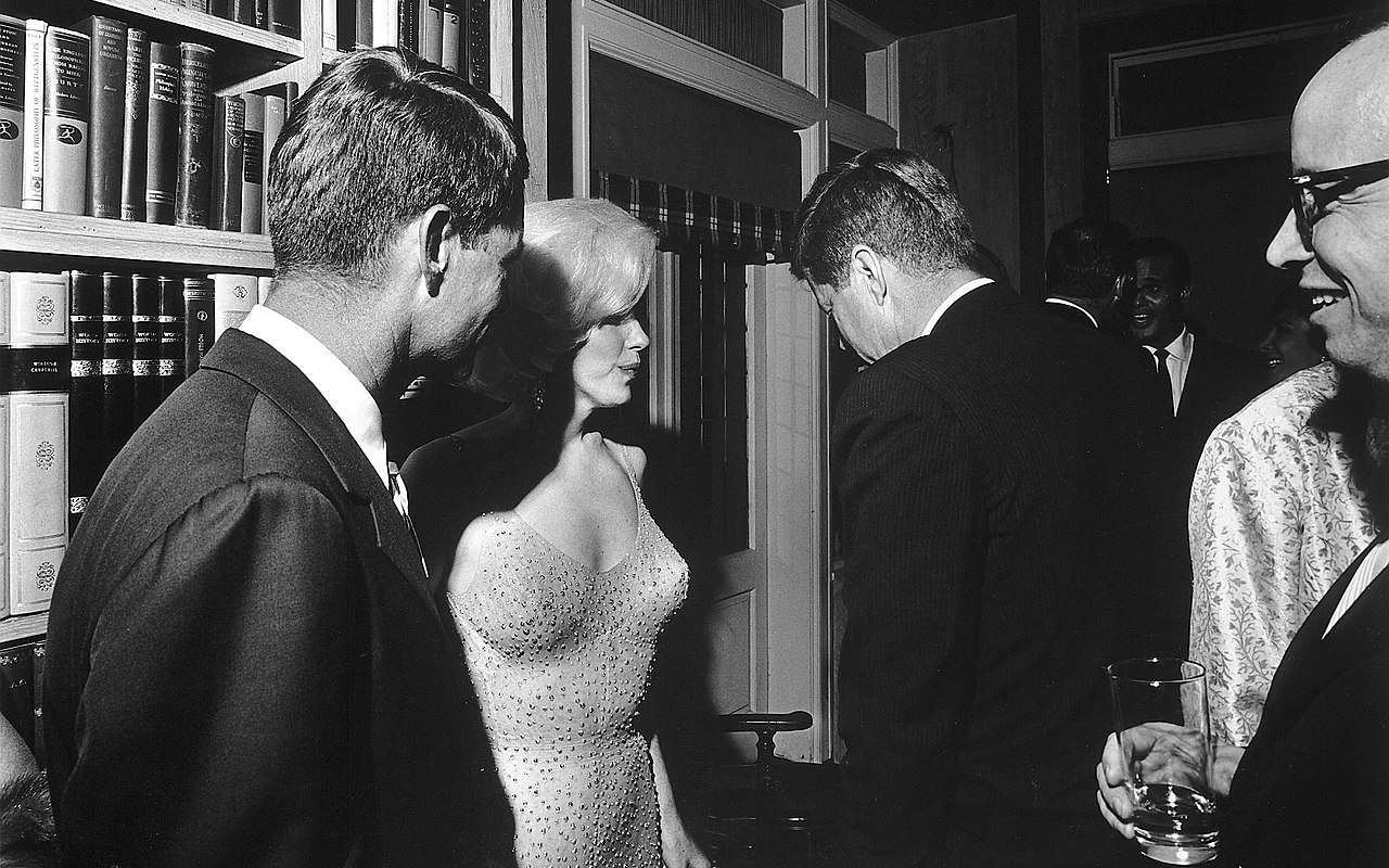 Attorney General Robert F. Kennedy, Marilyn Monroe, and John Kennedy talk during the president's May 19, 1962, early birthday party