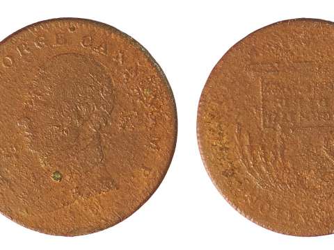 A worn copper-alloy medal depicting Canning